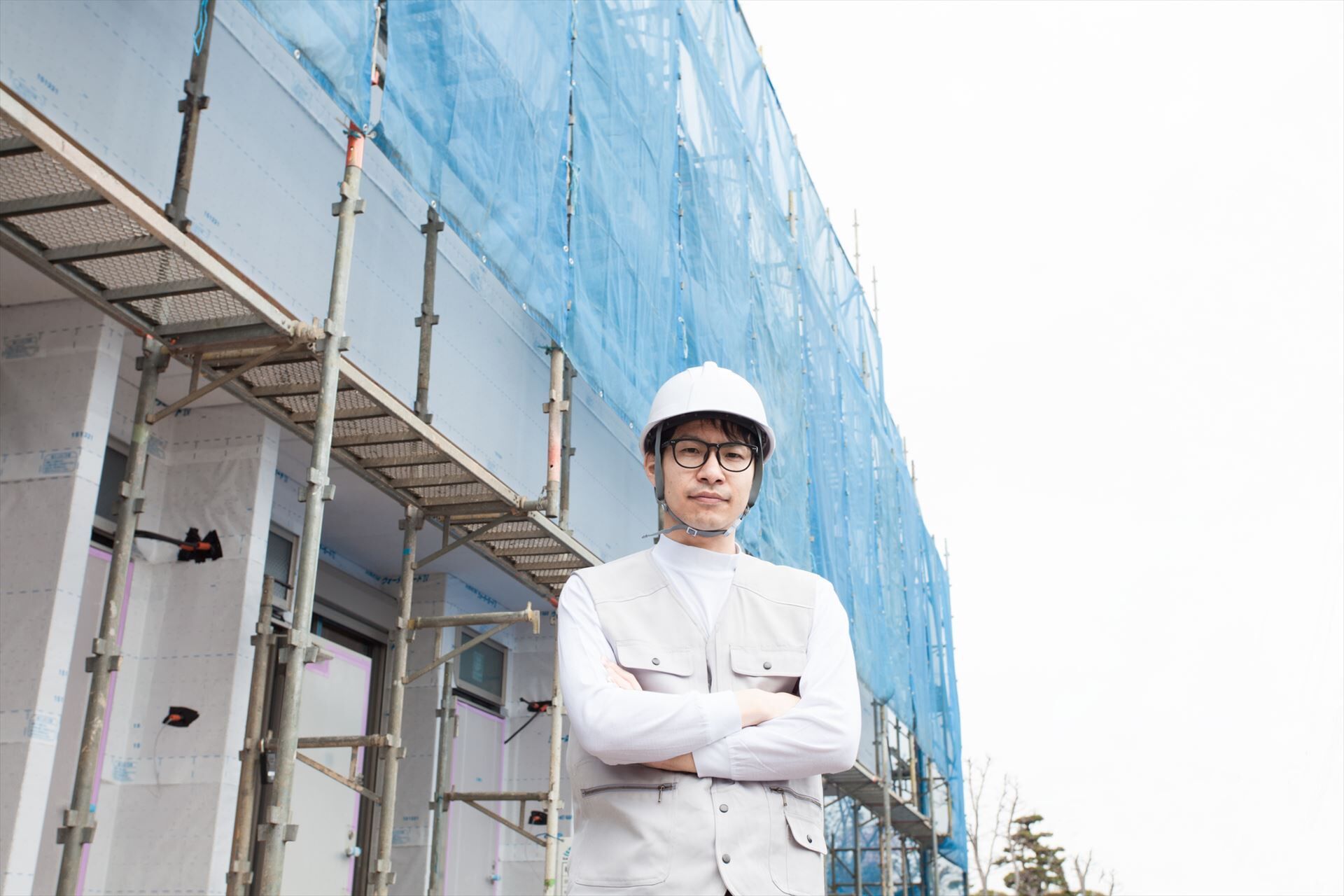 足場の前でポーズを決めるスタッフ